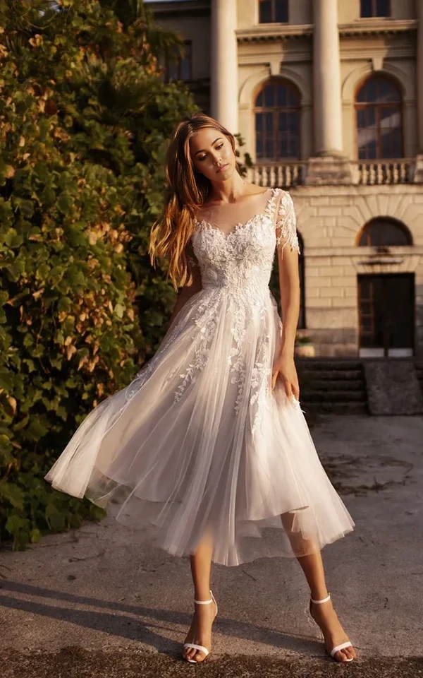 Vestido de novia de corte A, escote en V, mangas cortas, espalda con botones y corte etéreo